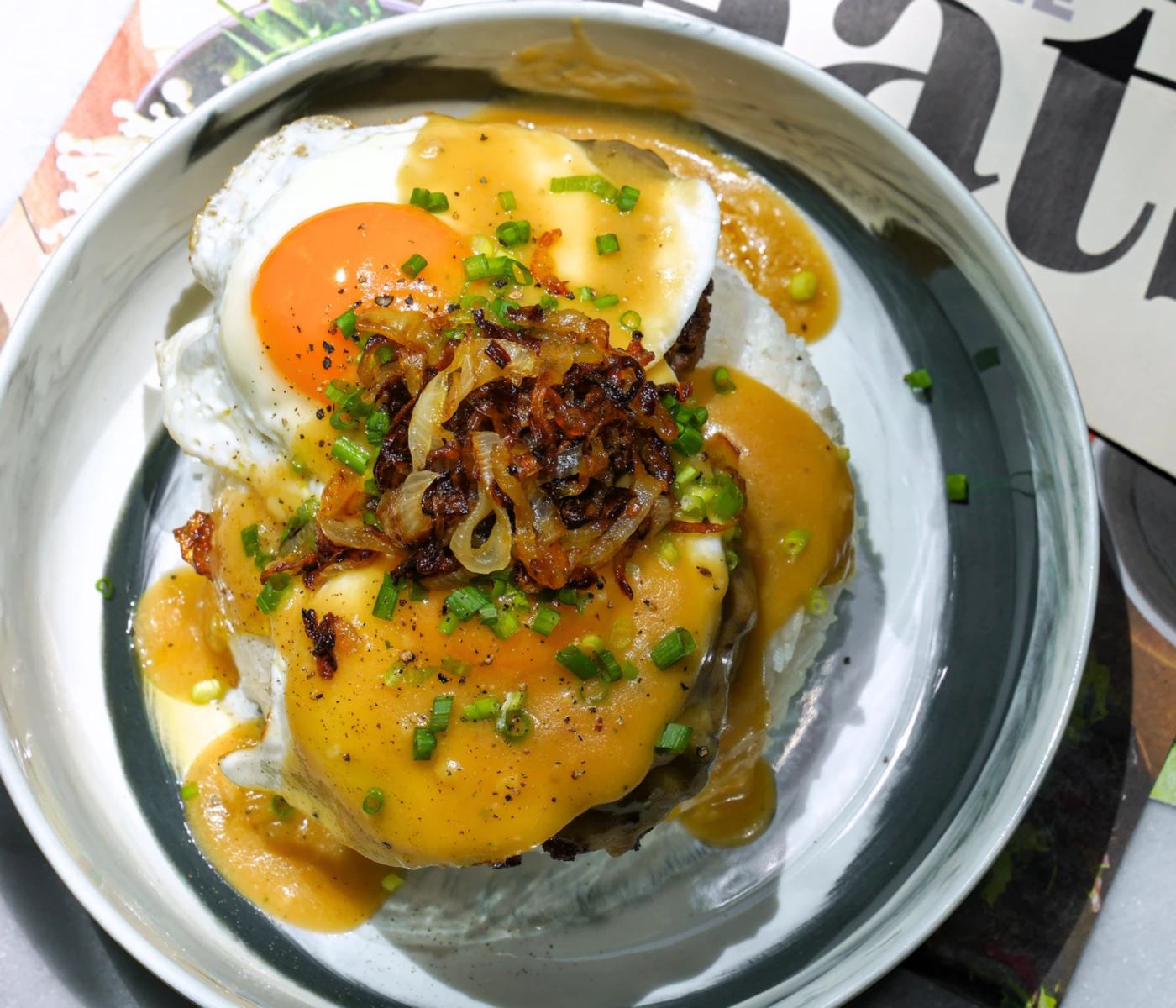 Classic loco moco with grilled onions and sunnyside up egg.