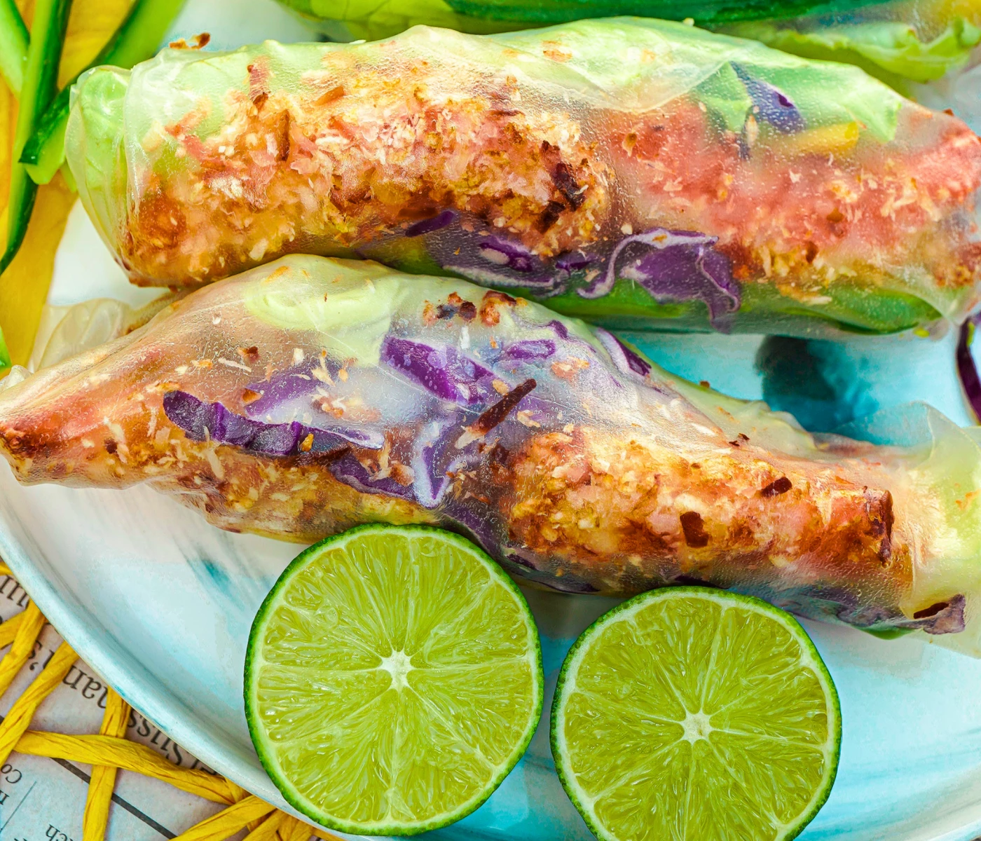 Coconut shrimp spring rolls with a lime cut in half.